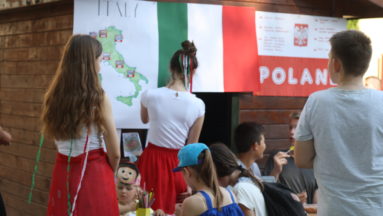 Zdjęcie przedstawia kilkoro młodych ludzi, oglądających plakaty na temat Włoch i Polski.
