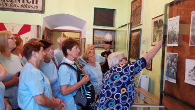 Zdjęcie przedstawia grupę seniorów podczas oprowadzania po muzeum.