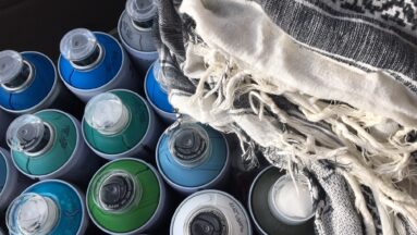 Zdjęcie przedstawia puszki z farbą w sprayu w różnych kolorach.