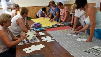 Wokół dużego stołu pracuje 10 pań. Zajmują się odrysowywaniem i wykrawaniem formatek do maskotek