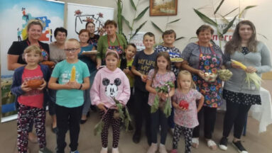 Grupa uczestników spotkania z warzywami w dłoniach