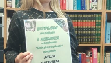 Zdjęcie przedstawia dziewczynkę trzymającą dyplom.