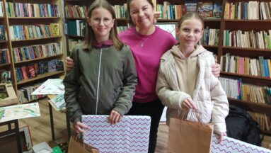 Zdjecie przedstawia kobietę i 2 dziewczynki pozujące z nagrodami.