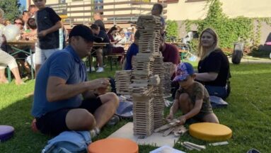 Uczestnicy cyklu spotkań warsztatowych „Klockowe Love” skupieni na tworzeniu dużych budowli z klocków Linden.