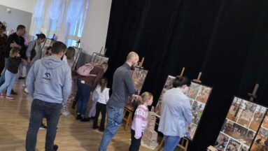 Uczestnicy wernisażu podziwiają  klockowe konstrukcje oraz zdjęcia dokumentujące przebieg warsztatów.